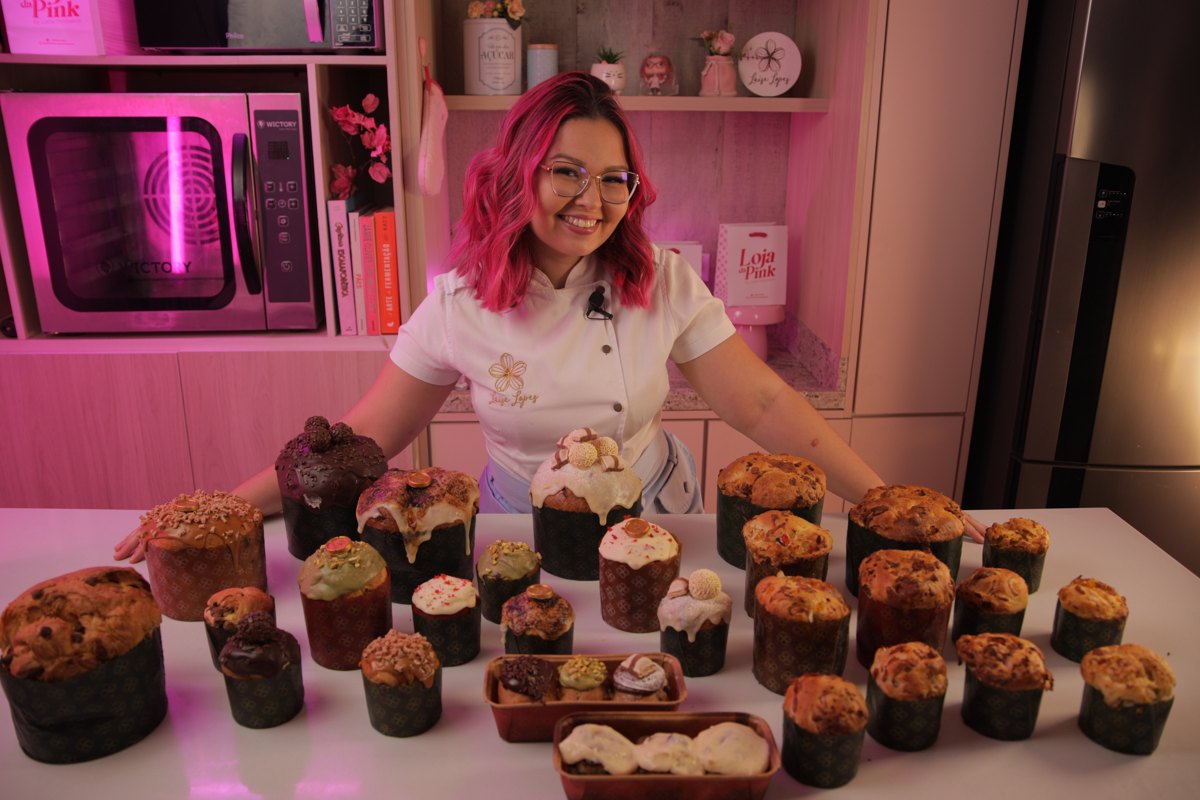 Chef Laís Lopes atrás da mesa com a produção inteira de panetones