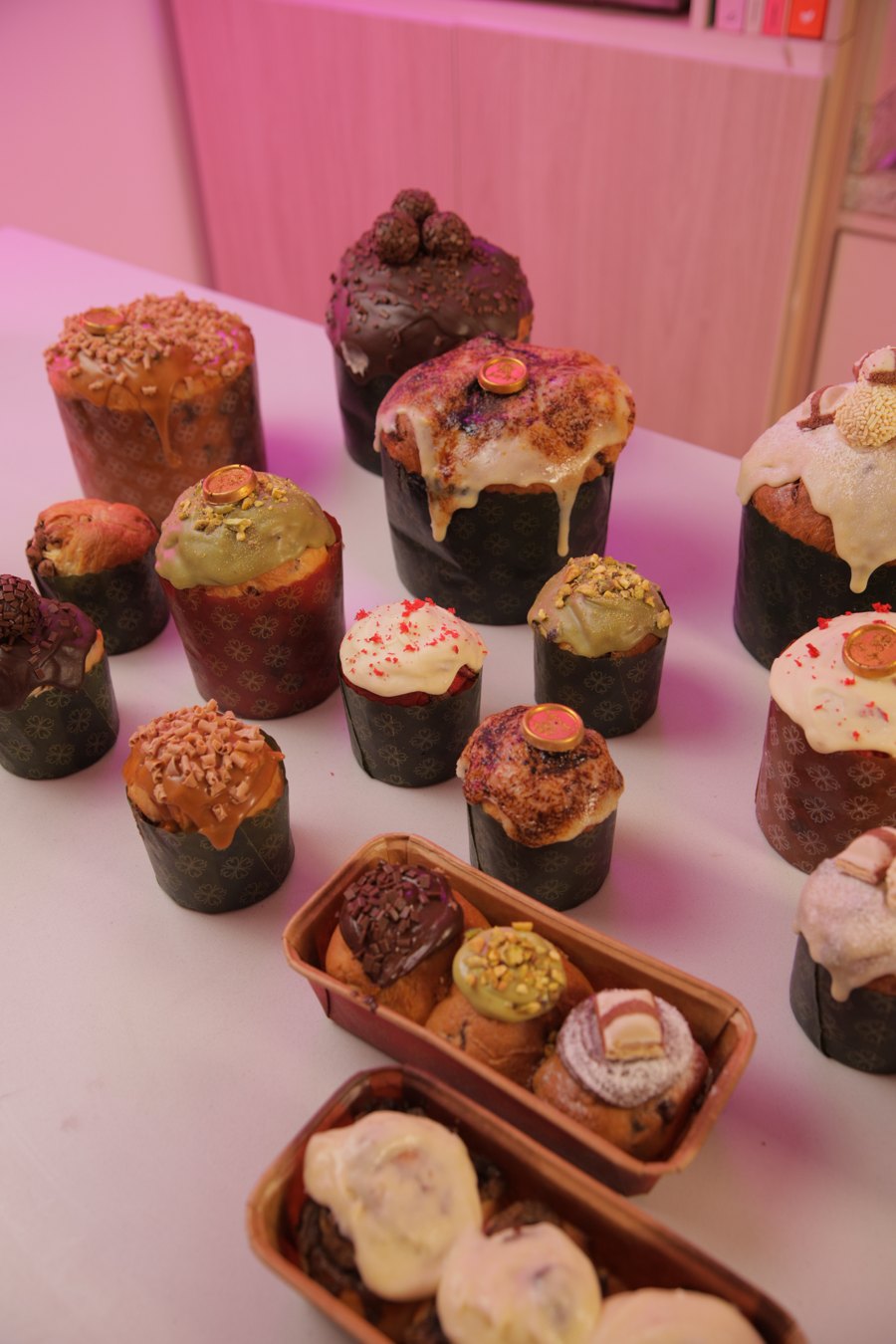 Mesa com panetones decorados e mini panetones em bandeja de madeira